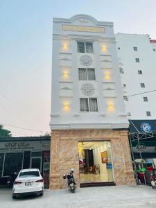 un coche blanco estacionado frente a un edificio en Khách sạn Xuân Dương, en Cửa Lô
