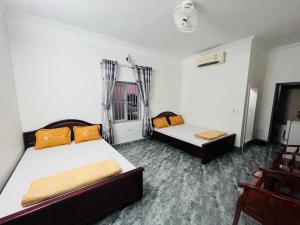 Habitación con 2 camas y una silla. en Khách sạn Xuân Dương, en Cửa Lô