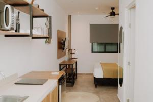 eine Küche und ein Schlafzimmer mit einem Bett in einem Zimmer in der Unterkunft Coco Live Suites in Playa del Carmen