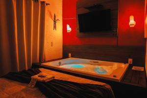 佛羅安那波里的住宿－Pousada Recanto do Aconchego，带电视的客房内的按摩浴缸