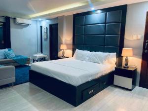 a bedroom with a large bed with a black headboard at SpittlerVilla in Talisay