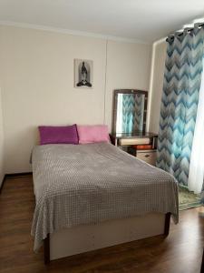 Schlafzimmer mit einem Bett und einem Spiegel in der Unterkunft Ай хаус in Tscholponata