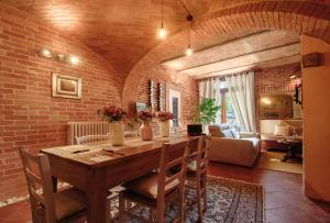 een eetkamer met een tafel en een bakstenen muur bij La Giolitta Rooms & Apartment in Barolo