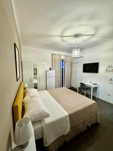 a bedroom with a large bed and a desk at IL RUGGI BB in Salerno