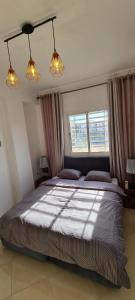 um quarto com uma cama grande e 2 janelas em Les portes de Gueliz - apartment 6 people em Marrakech
