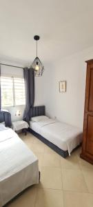 馬拉喀什的住宿－Les portes de Gueliz - apartment 6 people，一间卧室配有两张床和吊灯。
