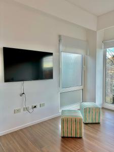 uma sala de estar com 2 bancos e uma televisão de ecrã plano em Turek Bahía Suites em Ushuaia