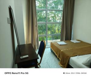 een slaapkamer met een bed, een bureau en een raam bij NaVita Lodge in Tamparuli