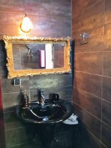 ein Bad mit einem Waschbecken und einem Spiegel in der Unterkunft Mojo Art House 