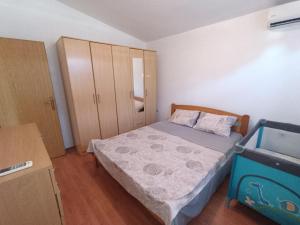 ein kleines Schlafzimmer mit einem Bett und einem Schrank in der Unterkunft Villa Irina in Bar