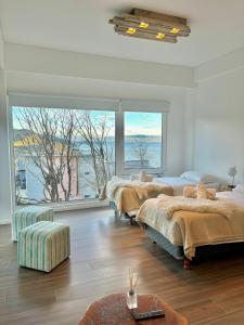 1 dormitorio con 4 camas y ventana grande en Turek Bahía Suites en Ushuaia