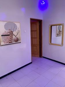 Pokój z białymi ścianami, drzwiami i lustrem w obiekcie Welltima Teranga w mieście Dakar
