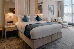 ターイフにあるفندق سويس انترناشونال الطائفの大きなベッドと椅子が備わるホテルルームです。