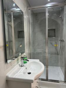 a bathroom with a white sink and a shower at Room with en-suite facilities in Ashford