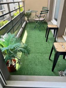 a balcony with a green floor with a table and chairs at appartement 2 pièces 5min gare val d'Europe parking inclus in Montévrain