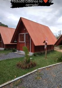 een huis met een rood dak bij Pousada Cabanas in Alto Paraíso de Goiás