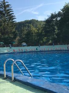 a swimming pool with chairs and blue water at Via Degli Dei Valserena in San Benedetto Val di Sambro +11 photos