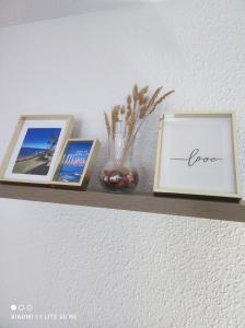 a shelf with three pictures and a vase on it at AlgaidaBeach-PaseoLitoral in Sitio de Calahonda