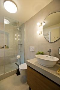 La salle de bains est pourvue d'un lavabo, de toilettes et d'un miroir. dans l'établissement Riva Yacht Hvar Town Apartment, à Hvar