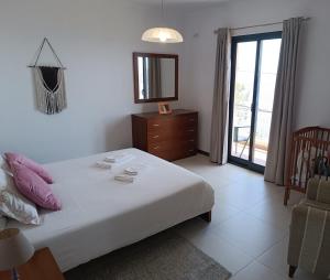 a bedroom with a bed with a mirror and a dresser at Villa Reis Sao Goncalo in Funchal