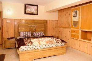 a bedroom with a bed in a room with wooden walls at Quality Inn Hotel in Murree
