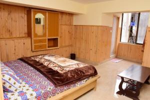 Un dormitorio con una cama y una mesa. en Quality Inn Hotel en Murree