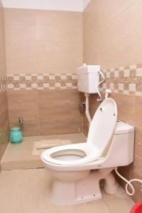 a bathroom with a white toilet and a shower at Quality Inn Hotel in Murree