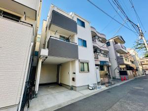 an apartment building with a garage on a street at MoRi House IN西日暮里Ⅱ in Tokyo
