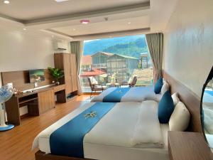 um quarto com 2 camas e uma grande janela em Ánh Sao Sapa Hotel em Sapa