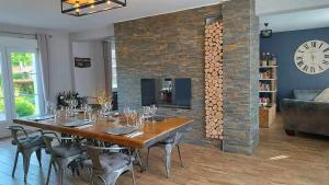 uma sala de jantar com uma mesa e uma lareira em Les Rêves de Baie de Somme Chambres d'hôtes , Table d'hôtes et Spa em Béhen