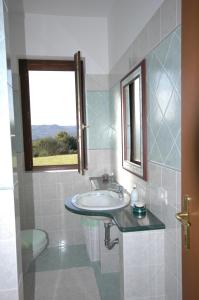 baño con lavabo, ventana y aseo en La Locanda San Lorenzo en Orte