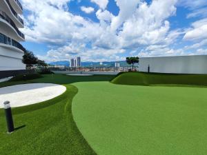 a golf course with a green and a building at Datum Jelatek Residences Royalty Luxury Apartment, Walking Distance To LRT, Gleneagles KL & KLCC in Kampong Datok Keramat