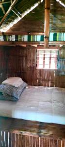 Cama en habitación de madera con techo de madera en Catalinas Mini-Farm en Victoria