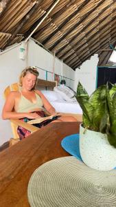 a woman sitting at a table with a plant at Palenque Beach House in San Onofre +56 photos