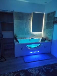 a bathroom with a tub with a blue light at Le temps d une escale in Lambesc