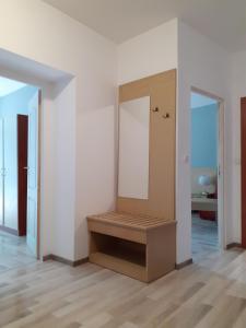 a white room with a bench and a mirror at Двустаен апартамент в Приморско in Primorsko