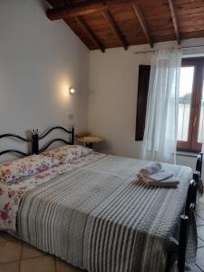 a bedroom with a bed with a blanket and a window at La Casa Rossa in Riola Sardo