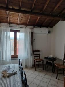 a room with a table and chairs and a window at La Casa Rossa in Riola Sardo