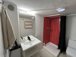 a bathroom with a sink and a red shower curtain at Centrally Apartment in El Raval in Barcelona