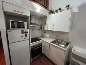 a small kitchen with white cabinets and a sink at Centrally Apartment in El Raval in Barcelona