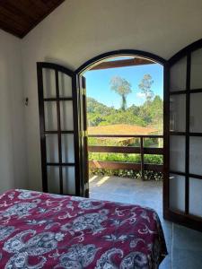 um quarto com uma porta aberta com vista para uma árvore em Chácara condomínio Porta do Sol em Mairinque