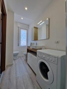 ein Badezimmer mit einer Waschmaschine und einem Waschbecken in der Unterkunft Residenza Luigiò in Verbania