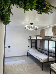Pokój z 2 łóżkami piętrowymi i żyrandolem w obiekcie Hostel Azamat w mieście Alamüdün