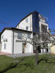 un edificio blanco con un árbol delante en Affittacamere Borgo degli Artisti boutique rooms, en Serricciolo