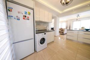 eine Küche mit einem Kühlschrank und einer Waschmaschine in der Unterkunft Turquoise Shores Family-Friendly Luxury Villa Fethiye Oludeniz by Sunworld Villas in Fethiye