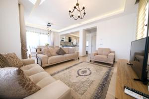 ein Wohnzimmer mit 2 Sofas und einem TV in der Unterkunft Turquoise Shores Family-Friendly Luxury Villa Fethiye Oludeniz by Sunworld Villas in Fethiye