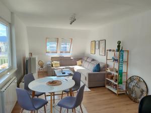 a living room with a couch and a table and chairs at Apartment 075 in Tuzla