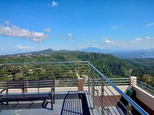 a bench sitting on top of a balcony with a view at Tagaytay Staycation - Casa Editha in Tagaytay