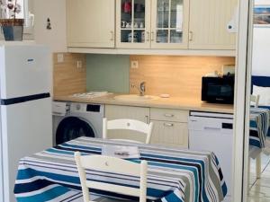 uma cozinha com uma mesa, um lavatório e uma máquina de lavar louça em Studio Saint-Martin-de-Ré, 2 pièces, 4 personnes - FR-1-544-25 em Saint-Martin-de-Ré