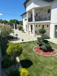 a house with a yard with bushes and trees at Pensiunea Coralia in Deva